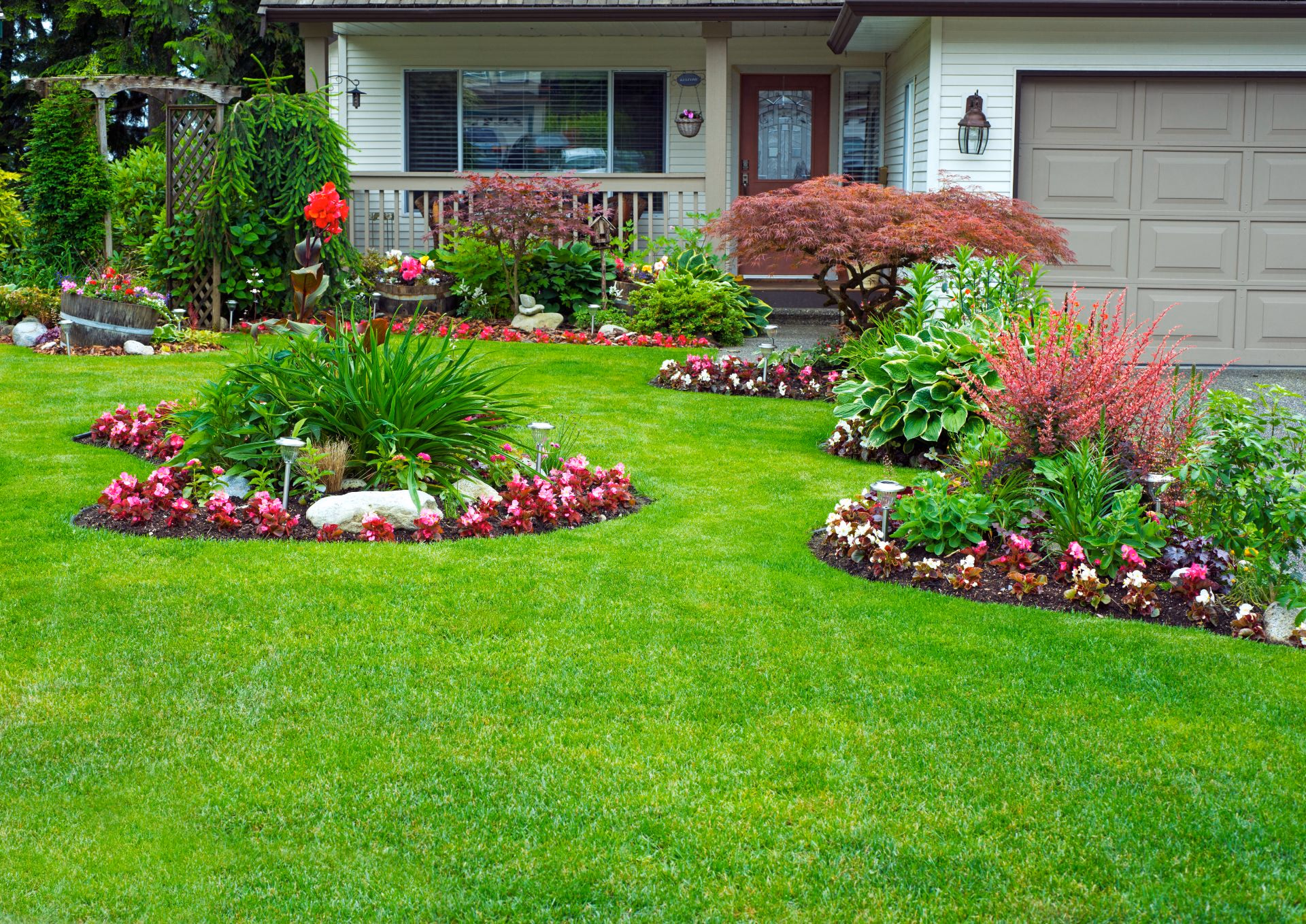 Front yard with flower beds around a green lawn