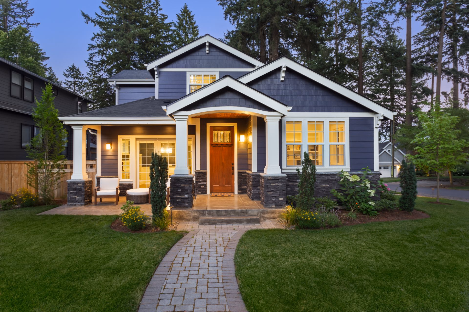 Craftsman-style home with a stone walkway across a green front lawn